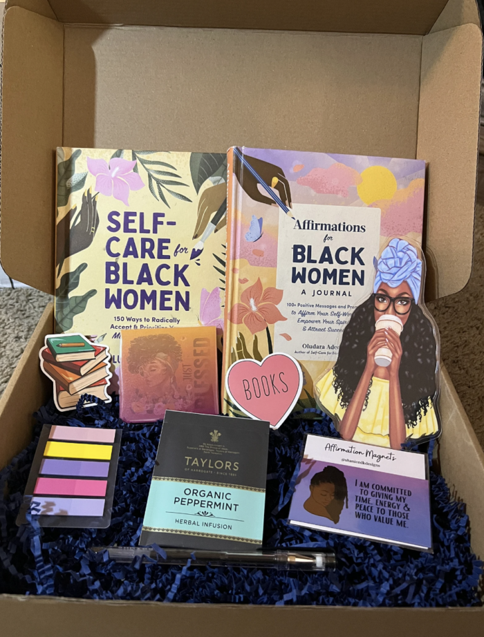 An open box with two books and other bookish goodies inside