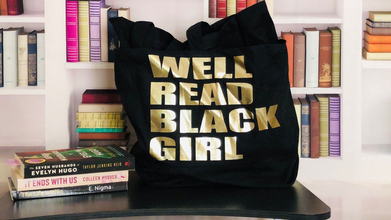 black tote bag that reads WELL READ BLACK GIRL in gold