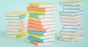 Three colorful stacks of books on light blue bckground