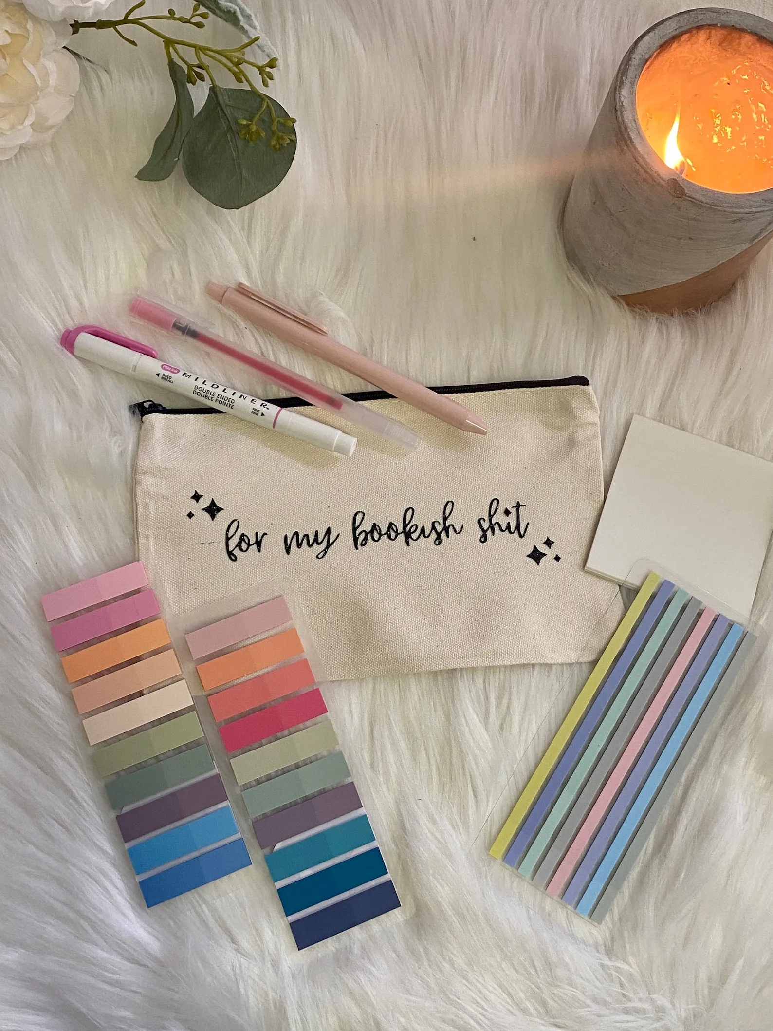 A canvas zipper pouch with flags, annotation strops, and pens.