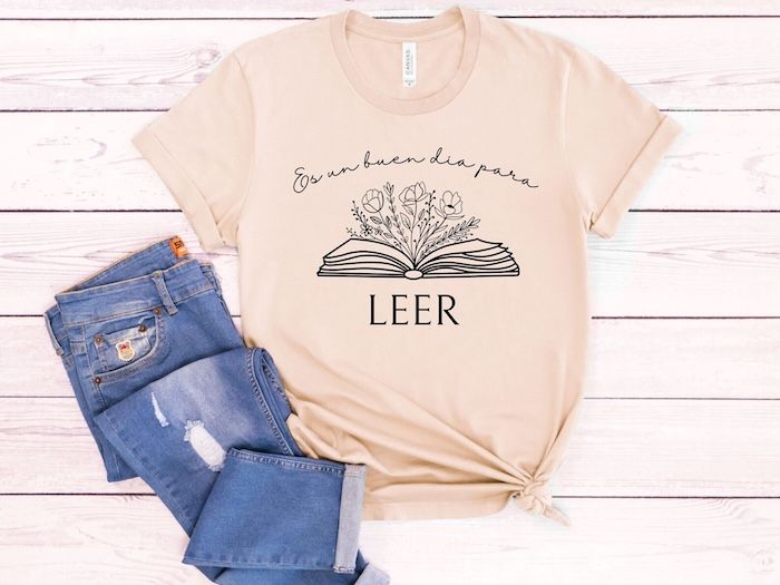 a light pink tshirt with the words "es un buen dia por leer" and an open book on it