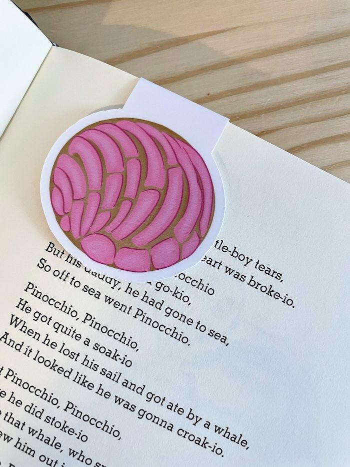 a pink concha bookmark on a book page