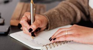 hands writing in a journal