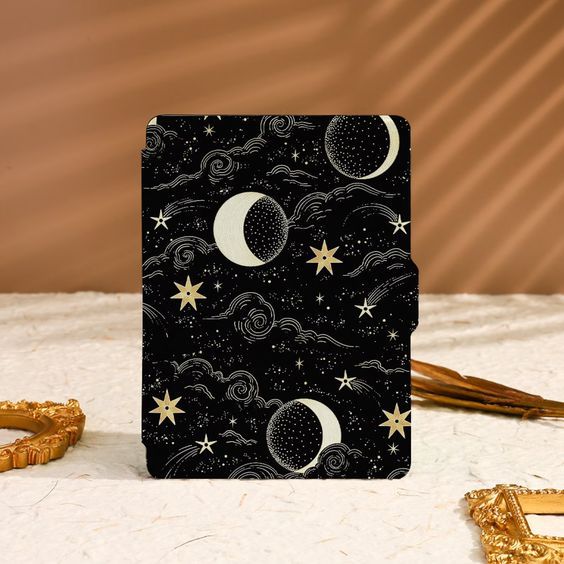 a hard black kindle case with a pattern of moon, clouds, and stars 
