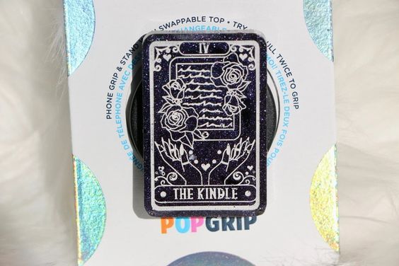 black rectangular pop socket with a tarot card design that reads The Kindle 