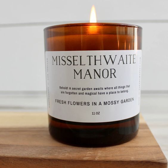 amber glass candle with a black and white label that reads "misselthwaite manor"
