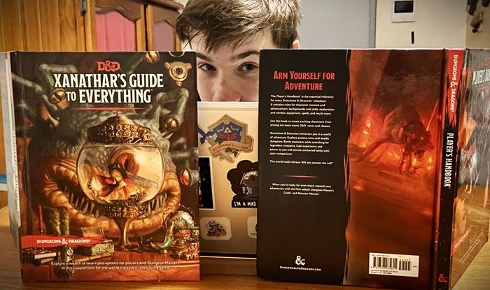image of dnd dm screen with DnD books and a teenager looking over the top