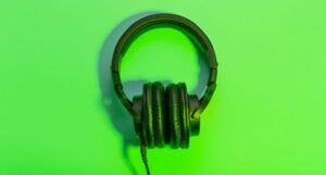 set of black over-ear headphones against a bright green background