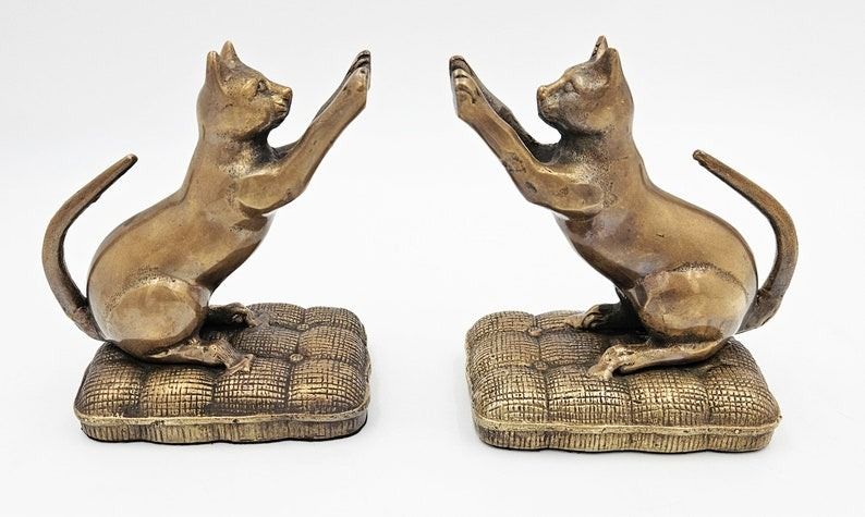 bronze bookends of cats with their paws up