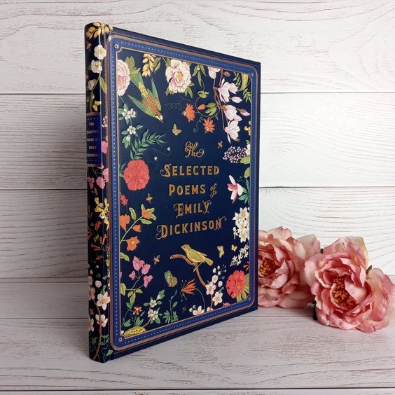 a navy blue book cover with bright florals and gold lettering reading "the selected poems of emily dickinson"