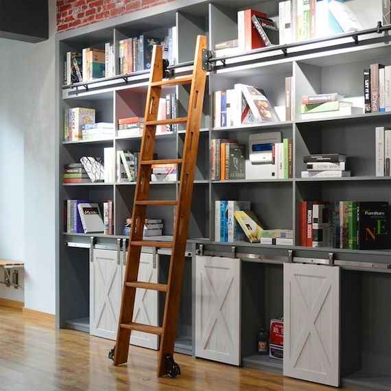 a wooden ladder on a rail across a bookcase