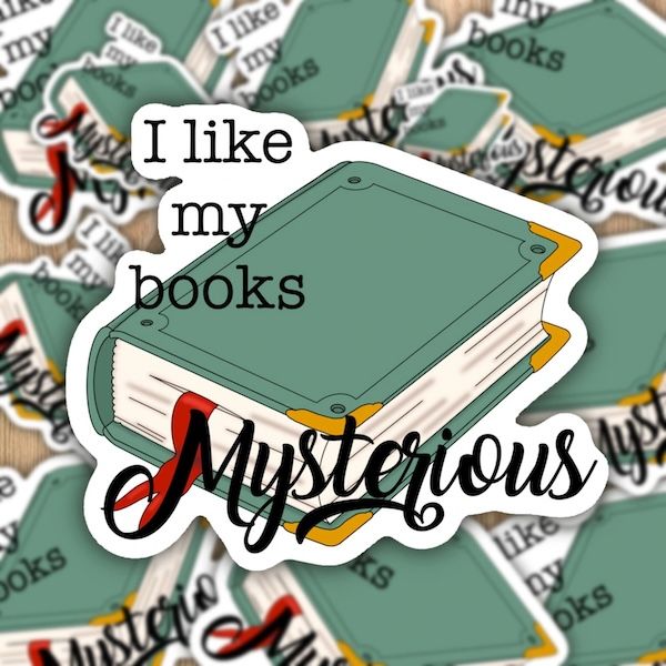 a sticker with the words "I like my books mysterious" in cursive script over a graphic of a sage green hardcover book