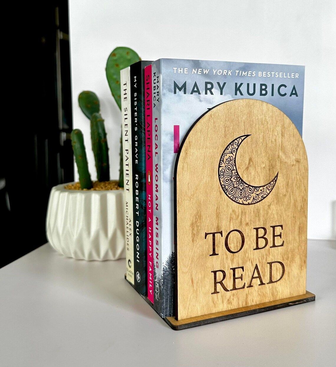 TBR stand with books and a moon etched on the front