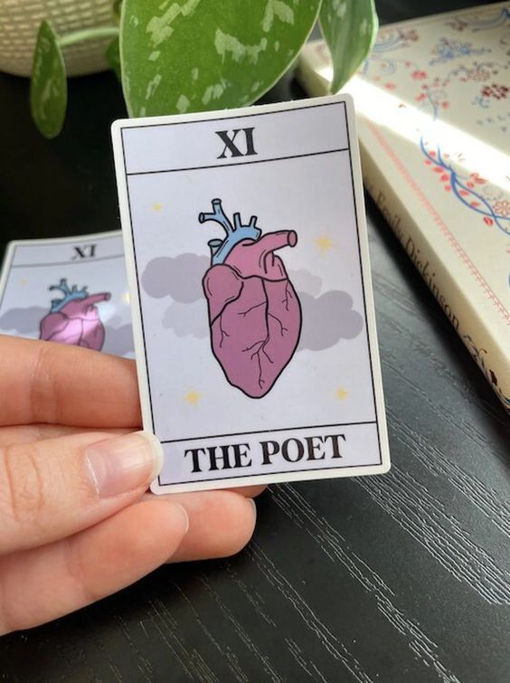 light colored sticker in the style of a tarot card, with a picture of an anatomically correct heart and the words "the poet"