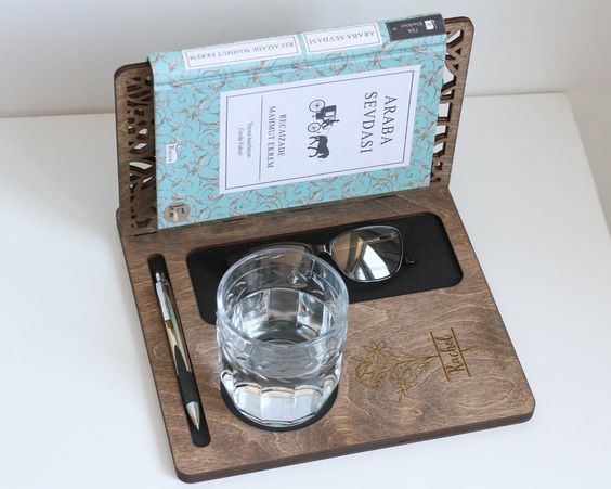 dark wood piece with spots for glasses, pen, and drink glass. There is also an extension meant to hold a physical book 