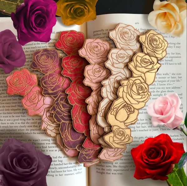 six woodcut rose bookmarks in assorted colors. each bookmark contains five rosebuds