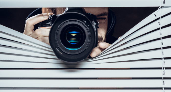 someone taking a photo from between blinds