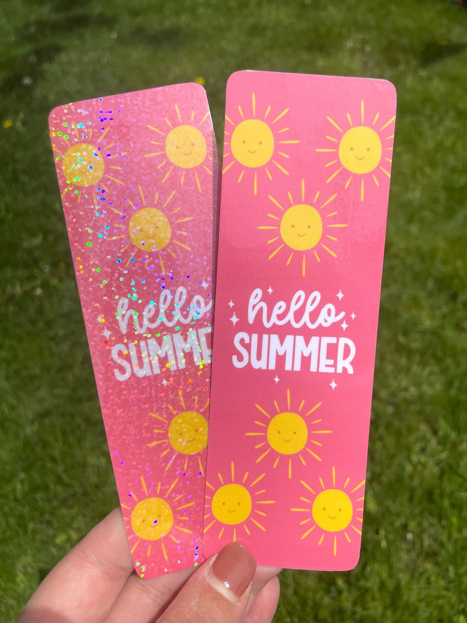 image of two pink bookmarks with yellow suns and glitter that say "hello summer." 