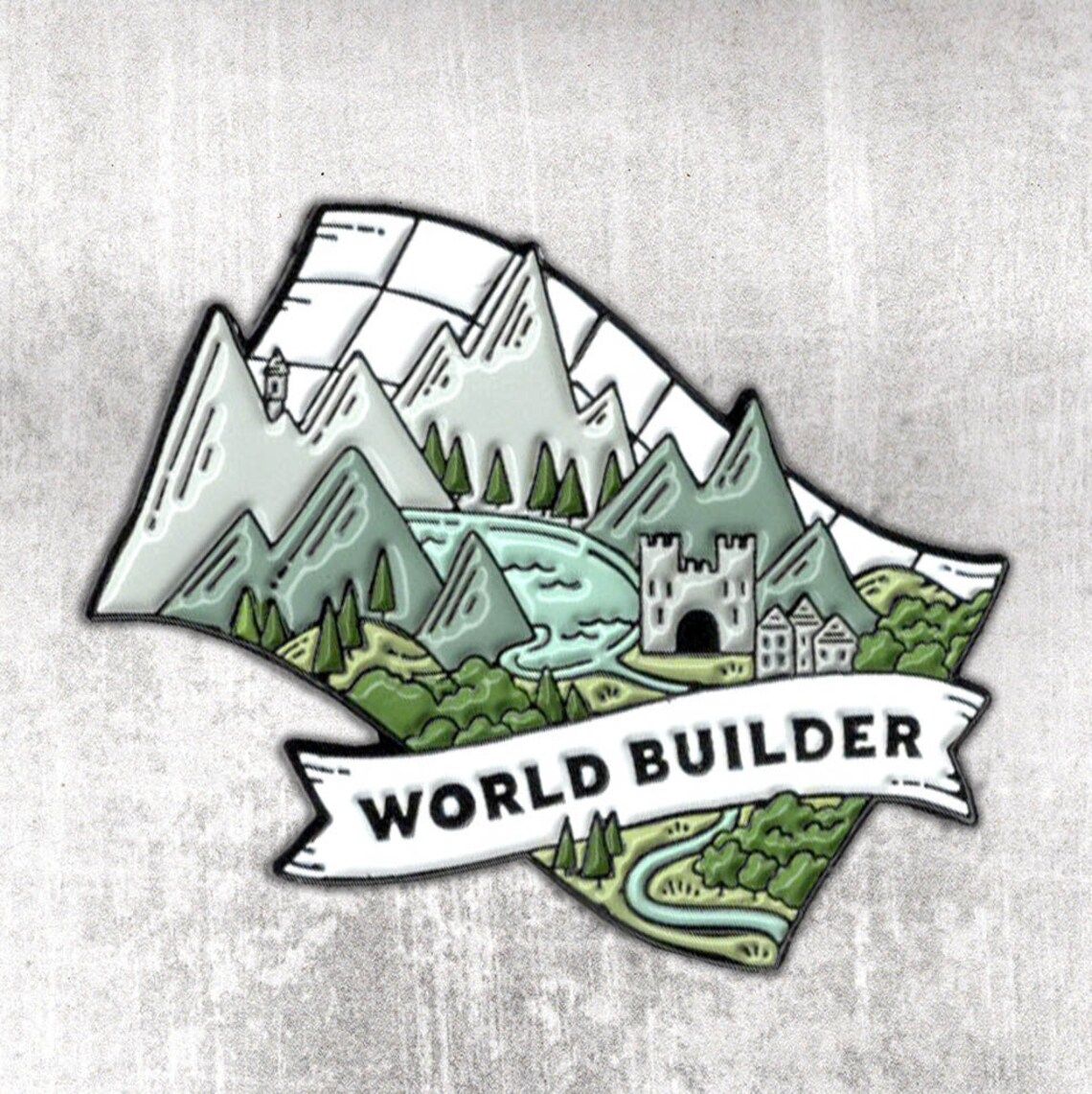 Enamel pin that says "world builder" with castle and landscape