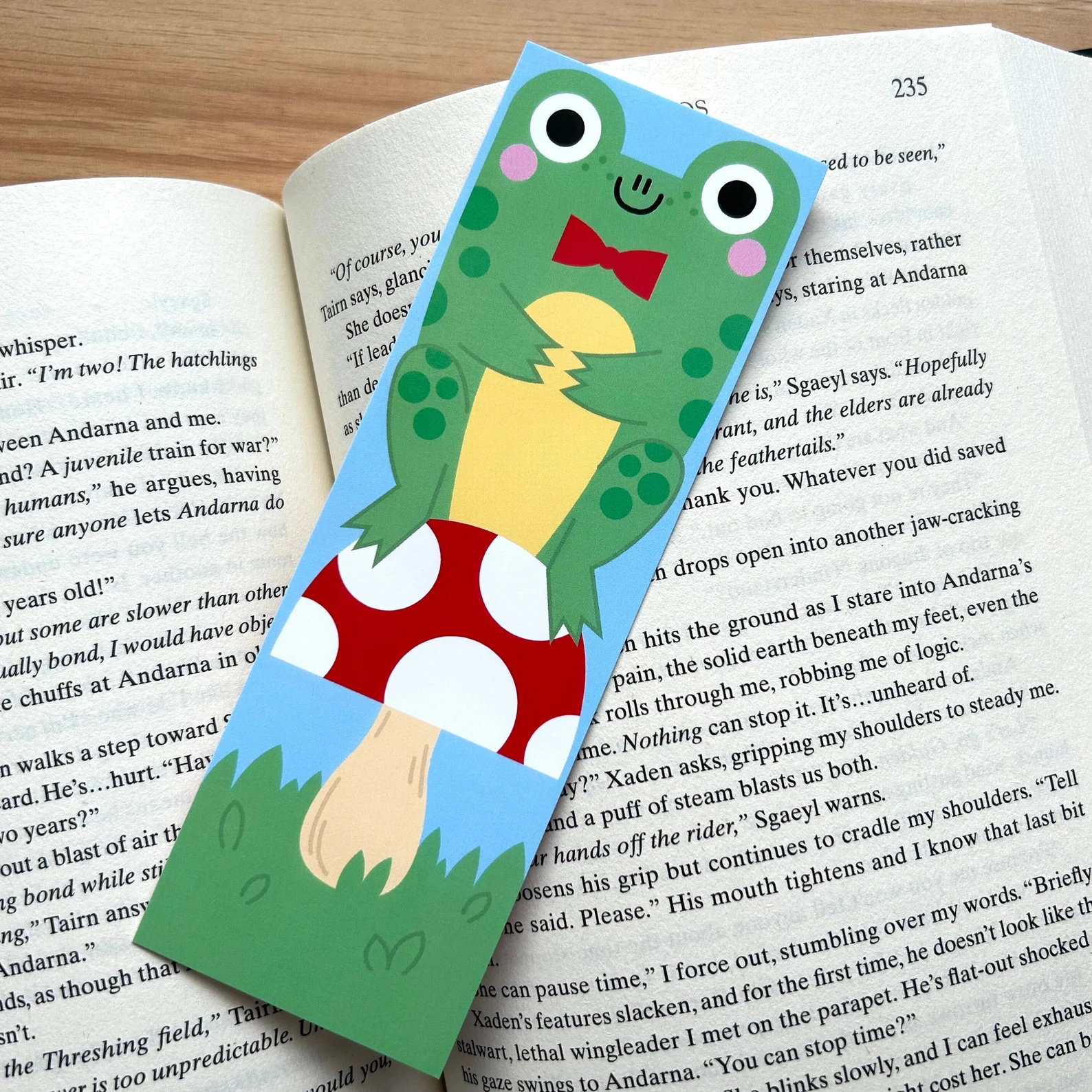 Image of a bookmark with a frog and a mushroom. 