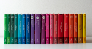 a shelf of books in rainbow order