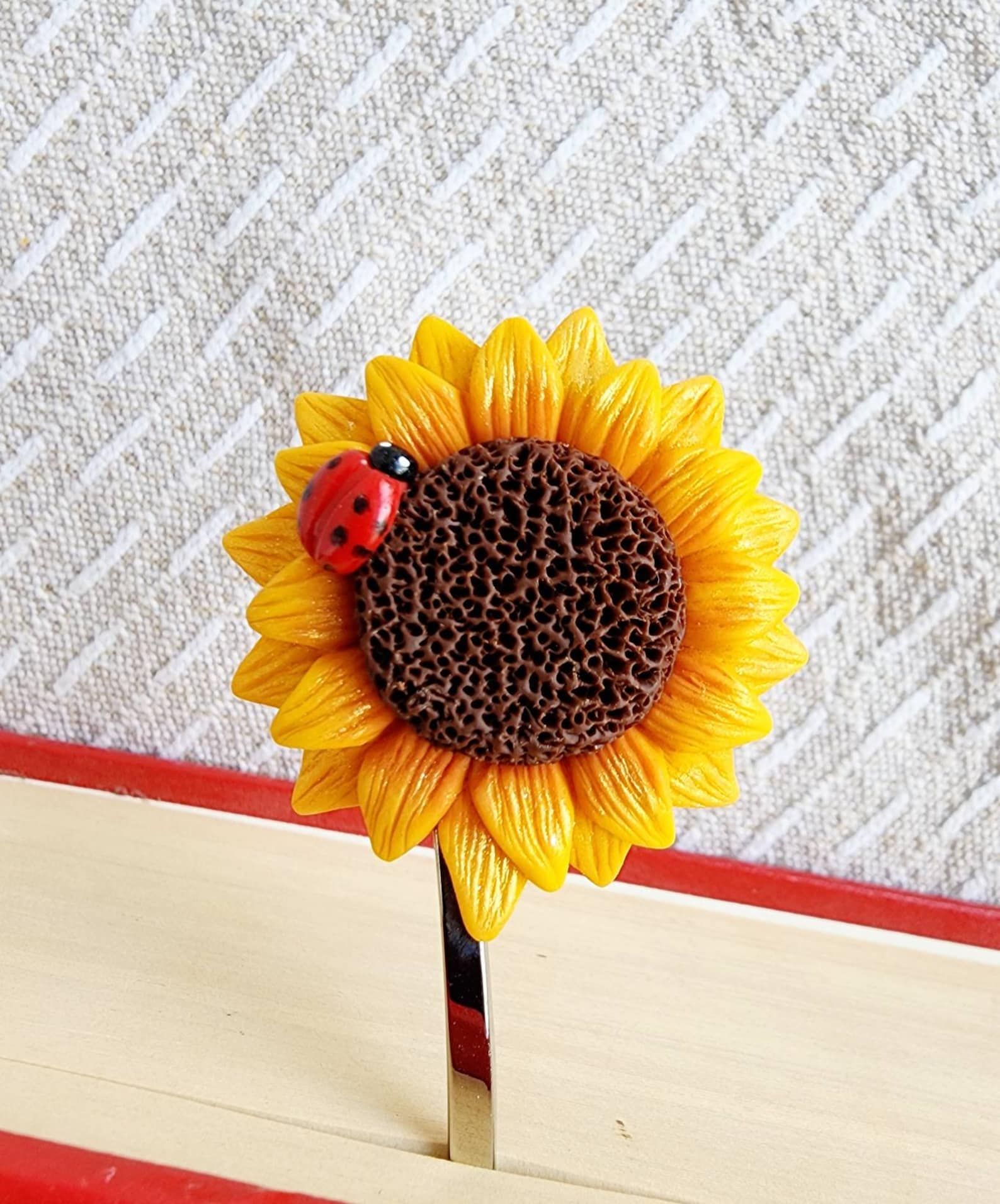 image of a polymer clay bookmark that is a sunflower and ladybug.