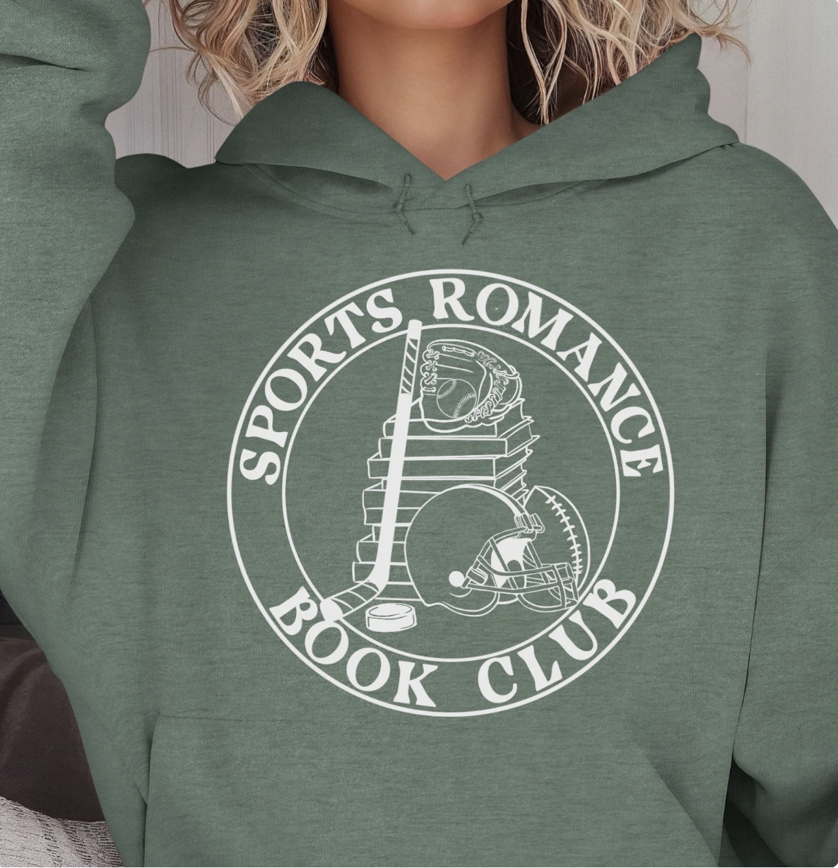 photo of a green hoodie with a round white logo that says "sports romance book club" with an illustration of a stack of book with various sports equipment