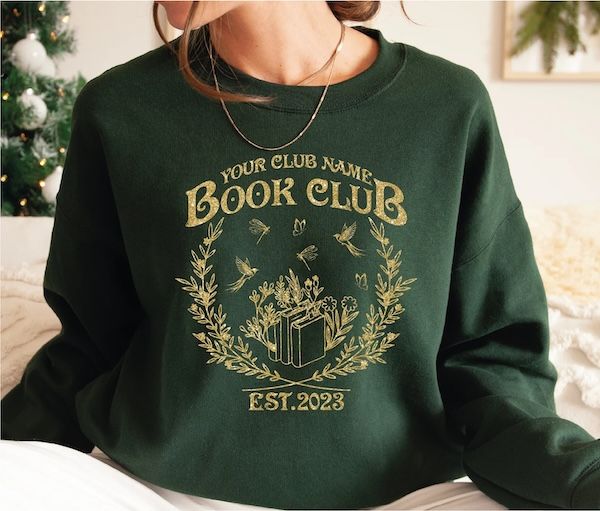 hunter green crewneck sweatshirt with gold text that reads "your club name book club" over a graphic of a laurel wreath surrounding a small stack of books