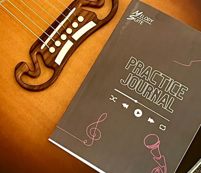 image of Music Practice Journal on top of a guitar