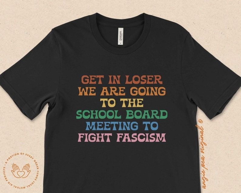 a shirt with rainbow letters that says Get in loser, we are going to the school board meetings to fight fascism