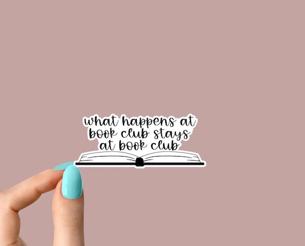 black and white enamel sticker of text that reads "what happens at book clun stays at book club"