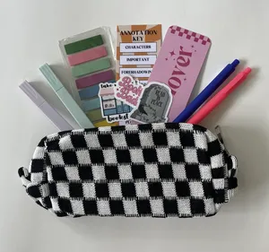 A black and white checkered pouch filled with supplies for book annotation including colored pens and highlighters, sticky note tabs, stickers, and bookmarks fanning out from inside the pouch.