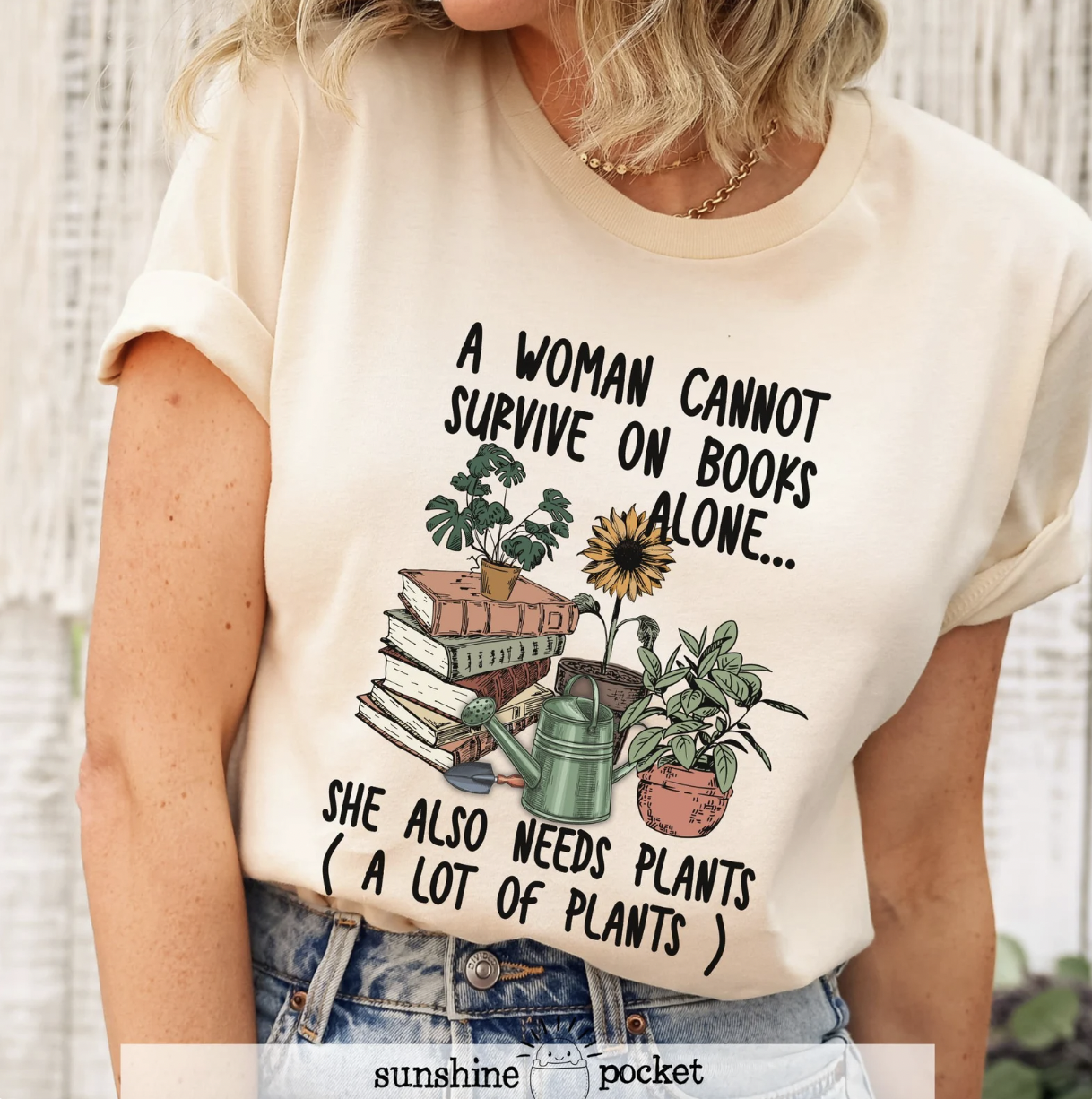 Image of someone wearing an ivory t-shirt with a graphic print of books and potted plants and the words: "A woman cannot survive on books alone. She also needs plats. (A lot of plants.)"