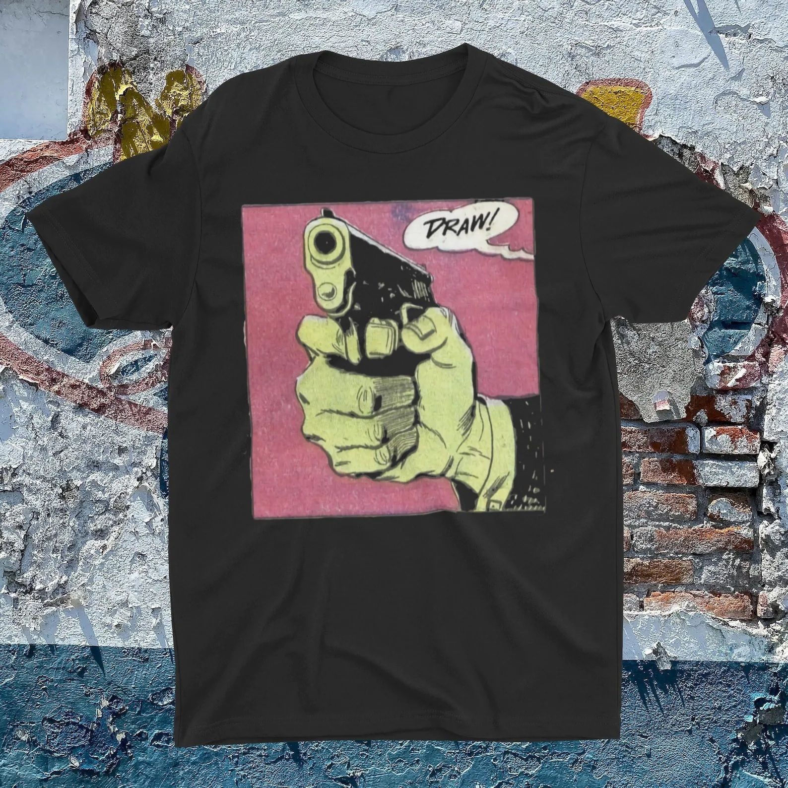 A black t-shirt with a comic book panel featuring a head holding a gun and a word balloon that says "Draw!"