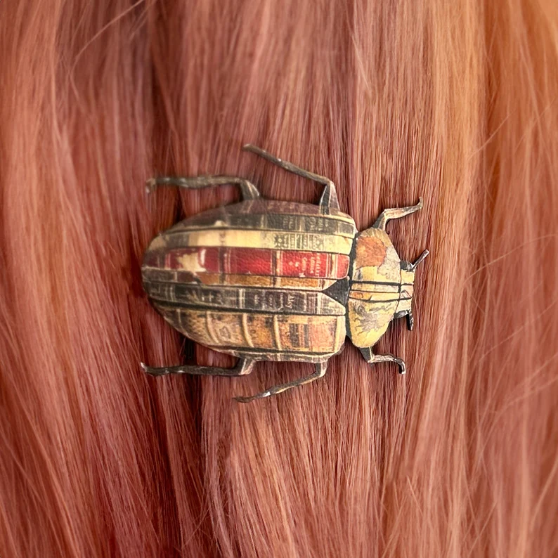 Beetle shaped hair clip printed with old book spines