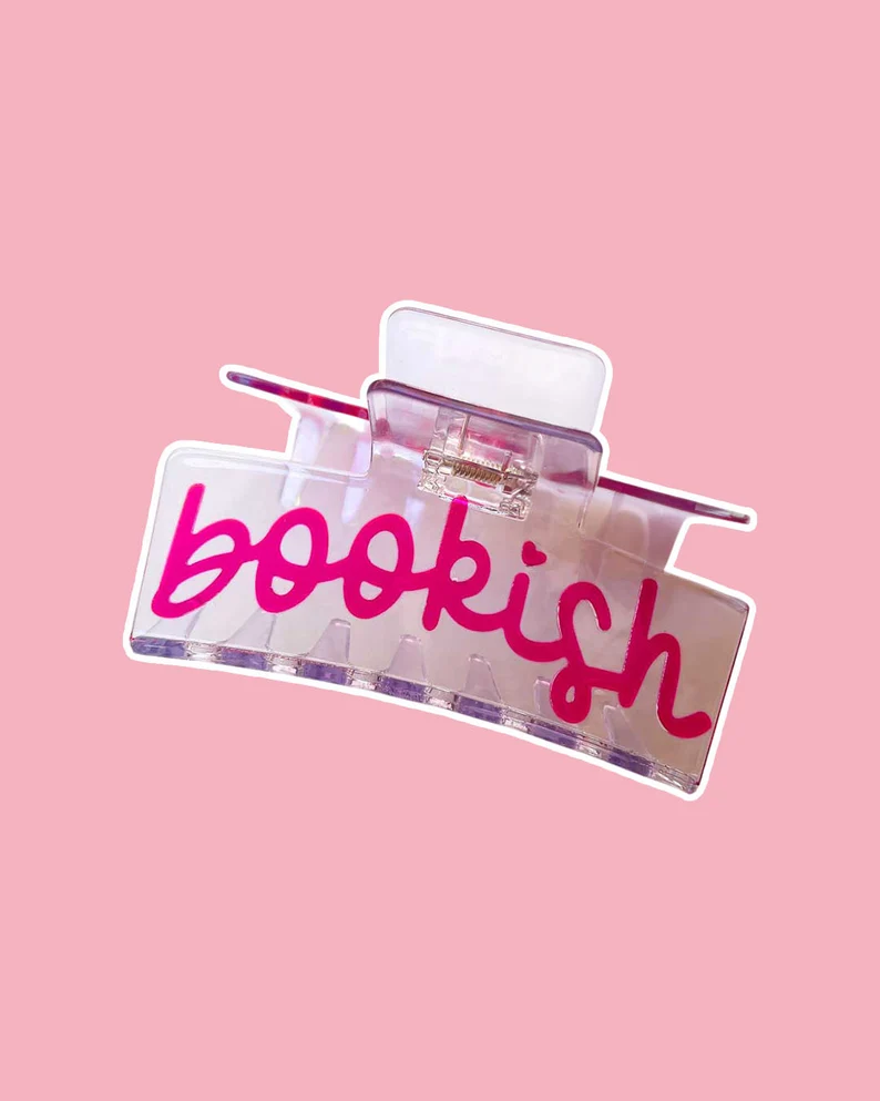 Clear claw clip that says "bookish" in pink cursive