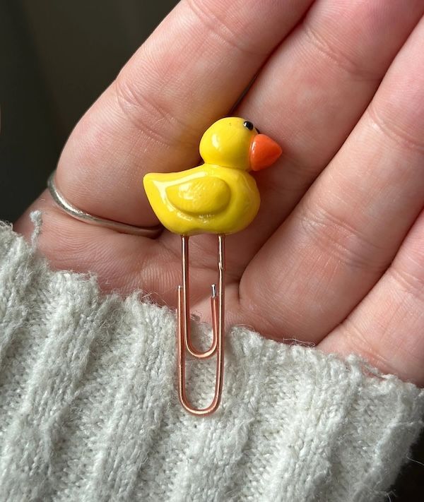 a tiny yellow duck attached to a paperclip for use as a bookmark