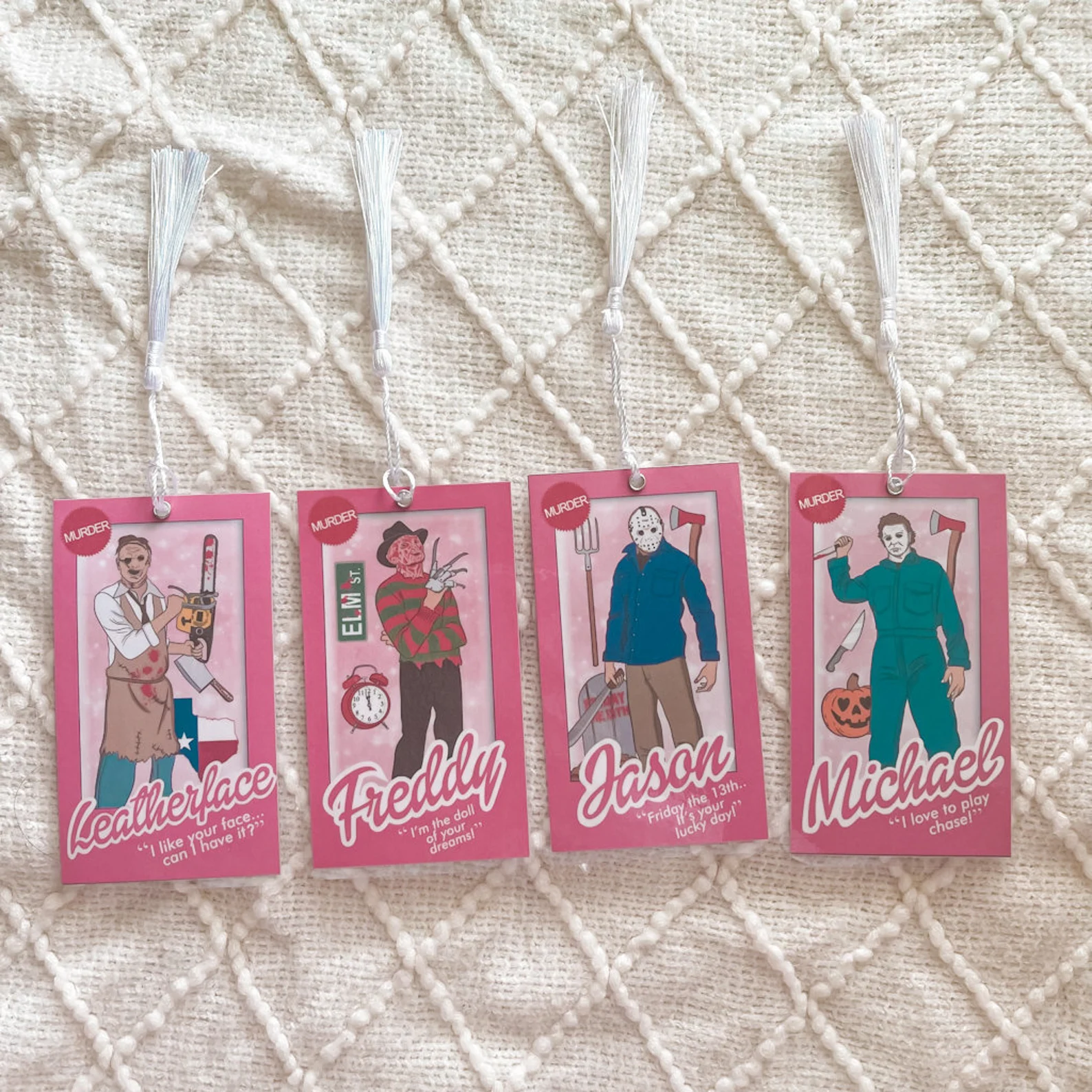 image of four bookmarks. they look like barbie boxes but have horror film villains in them. 