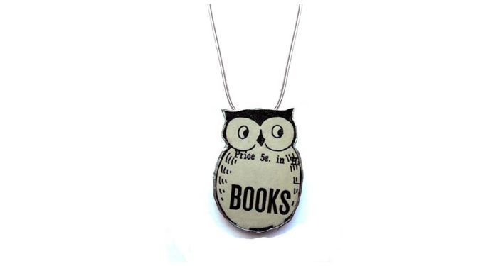 image of a necklace that is in the shape of an owl. on the owl's chest is the word books.