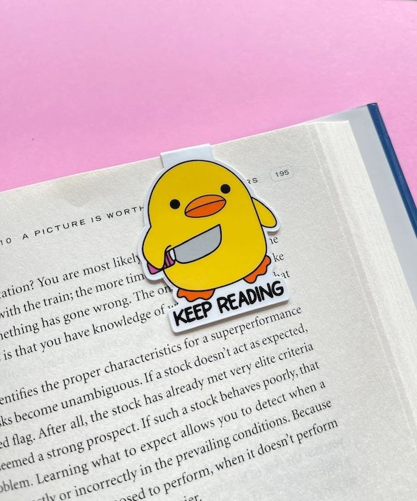 a magnetic bookmark of a yellow cartoon duck holding a knife with text beneath that says "keep reading"