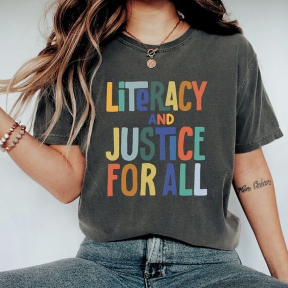 heather gray t shirt with colorful letters that read "literacy and justice for all"