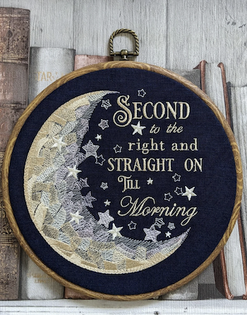 An embroidery piece framed in a wooden hoop with a peter pan quote