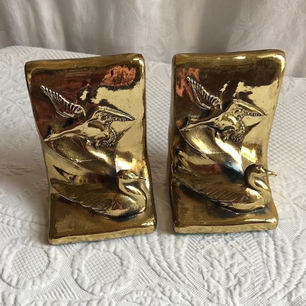 a pair of vintage square gold bookends with ducks in relief