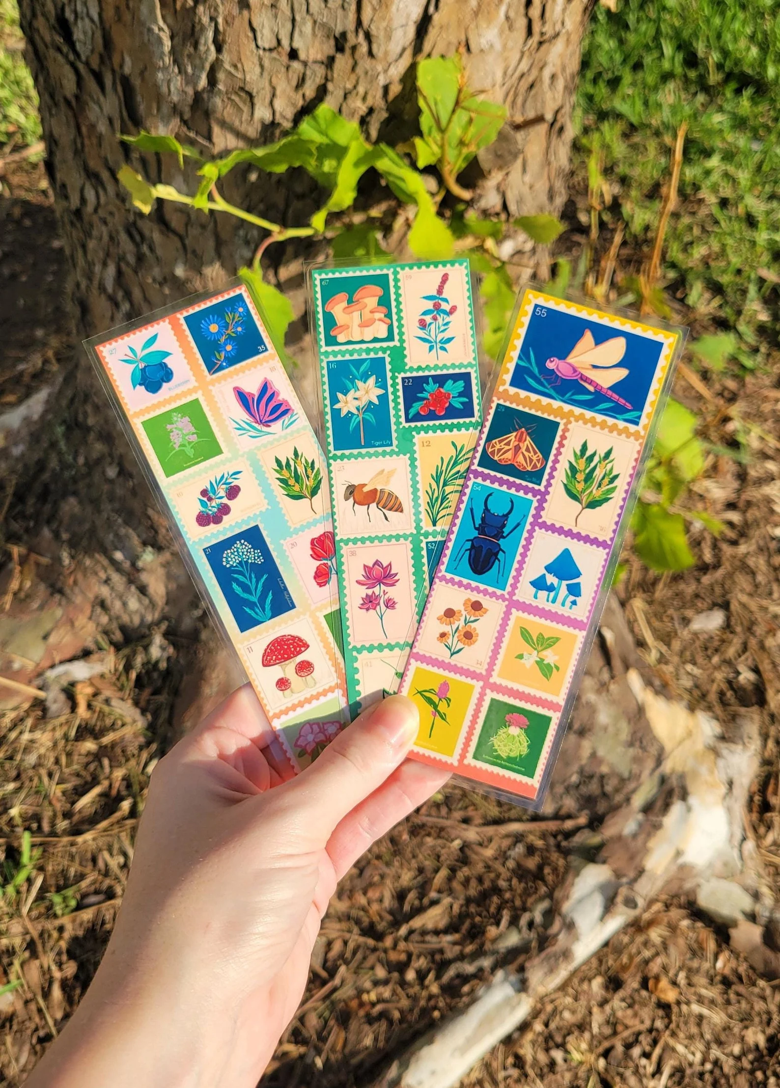 Image of three bookmarks featuring brightly colored vintage stamps with animals and plants. 