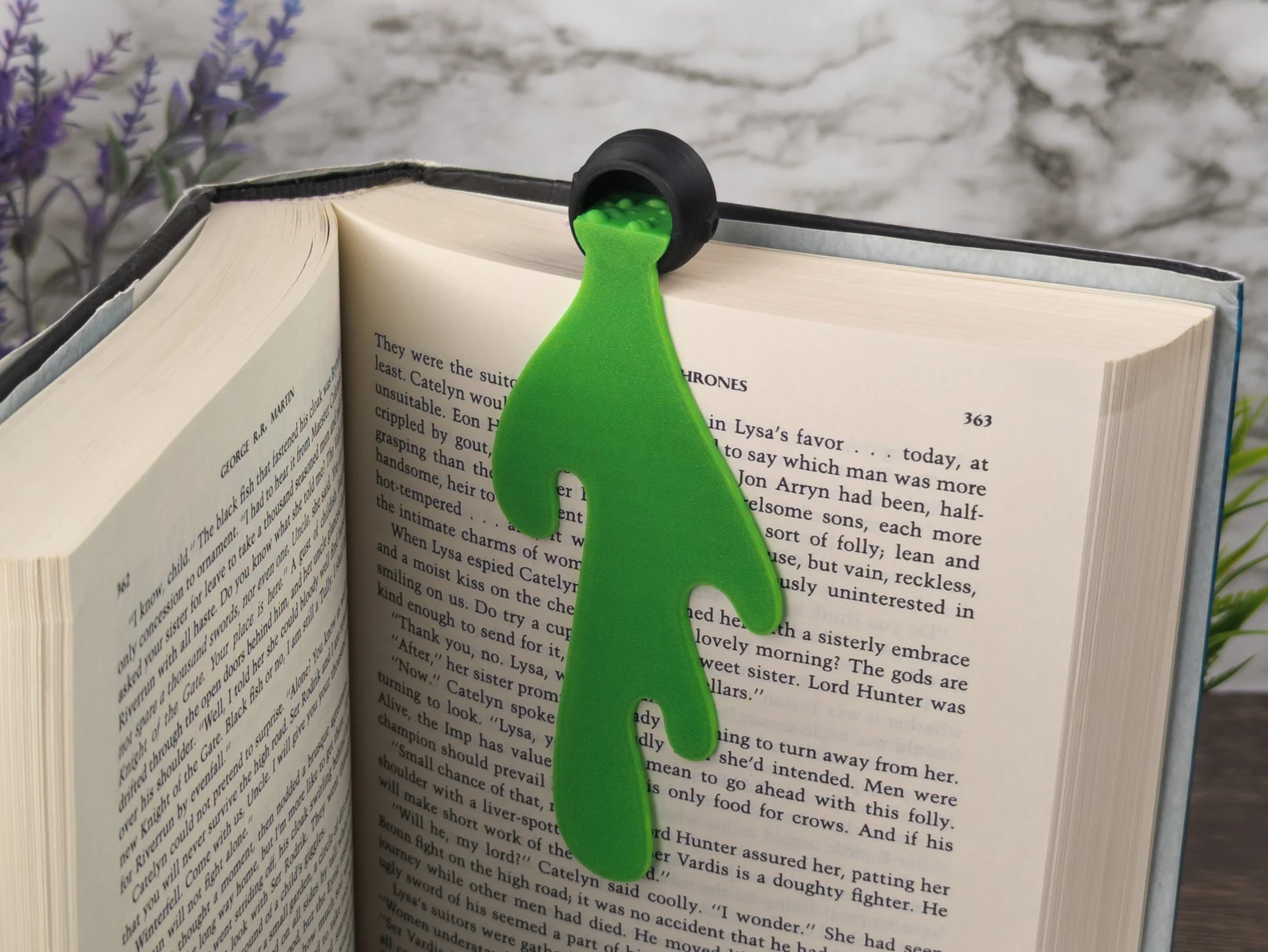 Image of a 3d printed bookmark that is in the shape of a spilled witch's cauldron. 