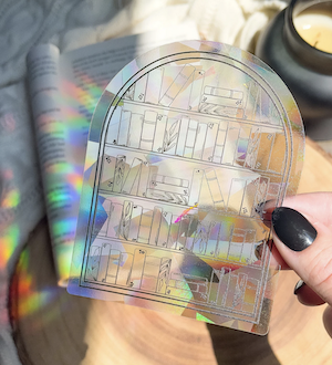 a vinyl sticker with outlines of an archway bookcase filled with books which reflects prism light when hit by sun