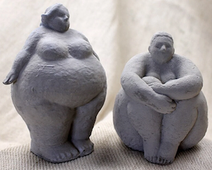 concrete bookends of a nude fat person sitting down and a nude fat person standing up