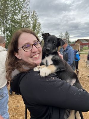 a woman holding an 8 week old husky puppy