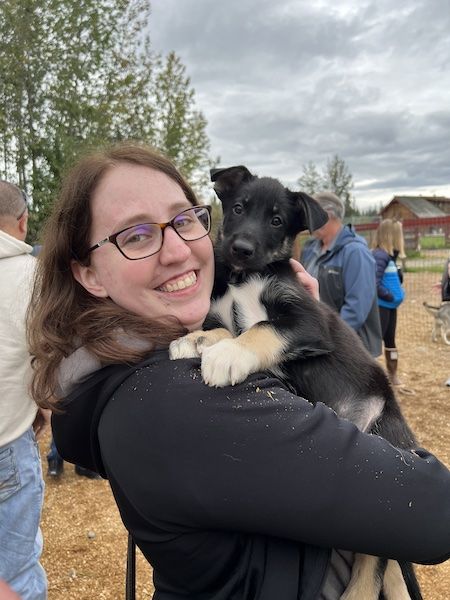 a woman holding an 8 week old husky puppy