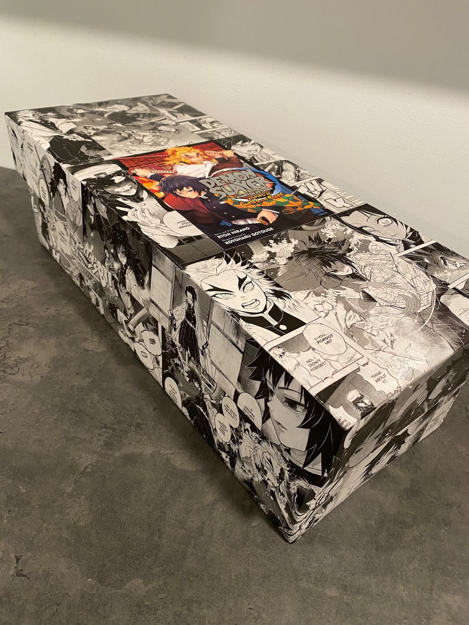 A long box covered in black-and-white manga images